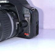 b) Canon EOS Rebel T1i DSLR Camera with 18-55mm Lens | 15.1MP | Full HD Video | Compact & Beginner Friendly | SK1032