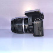 b) Canon EOS Rebel T1i DSLR Camera with 18-55mm Lens | 15.1MP | Full HD Video | Compact & Beginner Friendly | SK1032