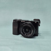 c) Sony A6100 Mirrorless Camera with Kit Lens – Excellent Condition