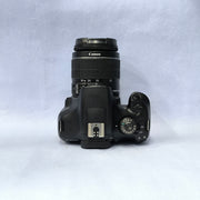 b) Canon EOS 1500D DSLR Camera with 18-55mm IS II Lens | 24.1MP | Full HD Video | WiFi | AB04