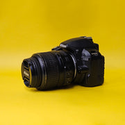 b) Nikon D3100 DSLR Camera with 18-55mm G VR Lens | 14.2MP | Full HD Video | Beginner Friendly DSLR | Budget Photography Camera | Code AB06 📸