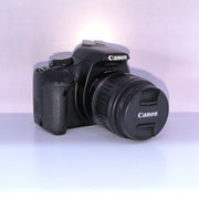 b) Canon EOS Rebel T1i DSLR Camera with 18-55mm Lens | 15.1MP | Full HD Video | Compact & Beginner Friendly | SK1032
