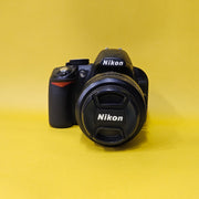 b) Nikon D3100 DSLR Camera with 18-55mm G VR Lens | 14.2MP | Full HD Video | Beginner Friendly DSLR | Budget Photography Camera | Code AB06 📸