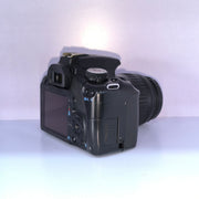 b) Canon EOS Rebel T1i DSLR Camera with 18-55mm Lens | 15.1MP | Full HD Video | Compact & Beginner Friendly | SK1032