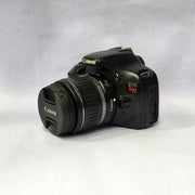 a) Canon EOS Rebel T2i DSLR Camera with 18-55mm Lens | 18MP | Full HD Video | Perfect for Beginners & Creators SK1039