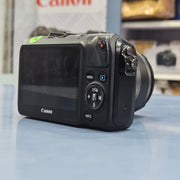 a) Canon EOS M Mirrorless Camera with 18-55mm Lens | Compact APS-C Camera (Code: AB36)