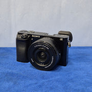 c) Sony Alpha A6000 + 16-50mm OSS Lens – Perfect for Photography & Video