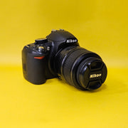 b) Nikon D3100 DSLR Camera with 18-55mm G VR Lens | 14.2MP | Full HD Video | Beginner Friendly DSLR | Budget Photography Camera | Code AB06 📸