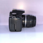 b) Canon EOS Rebel T1i DSLR Camera with 18-55mm Lens | 15.1MP | Full HD Video | Compact & Beginner Friendly | SK1032