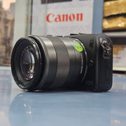 a) Canon EOS M Mirrorless Camera with 18-55mm Lens | Compact APS-C Camera (Code: AB36)