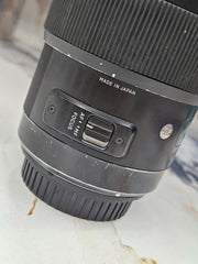 a) Sigma 50mm f/1.4 DG HSM Art Lens (Canon EF Mount) | Ultra-Sharp Prime | Beautiful Bokeh | Low-Light Performer | SK1050