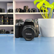 a) Canon EOS 750D DSLR Camera with 18-55mm III Lens | 18MP | Full HD Video | Flip Screen | Beginner Friendly | SK1034