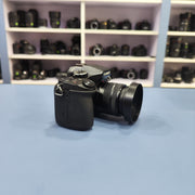 b) Panasonic Lumix G85 Mirrorless Camera Body – 4K Video & 5-Axis Stabilization | SK1023